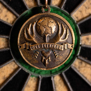 Primary Love Everybody pendant design hovered over the bullseye of a dartboard