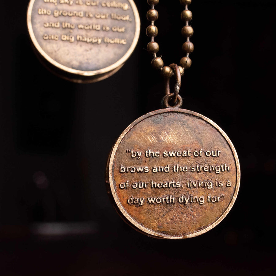 Closeup of medallion inscribed with inspirational phrase, side B